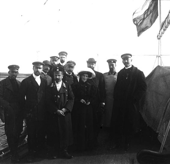 plaque de verre photographique ; Groupe comprenant 10 hommes et une femme sur le premier plan. Commandant C. Bénard est sur la droite