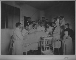 tirage photographique ; Une séance d'opération de M.Moure, chargé du cours de larygologie [laryngologie].