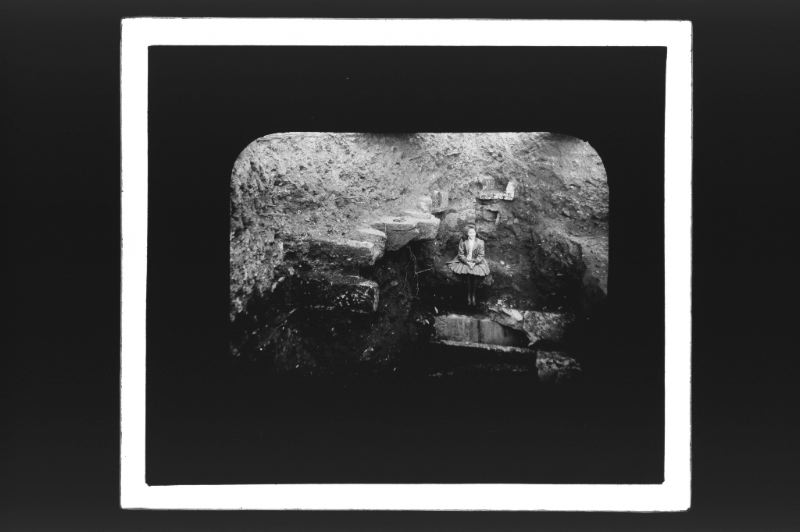plaque de verre photographique ; Jeune fille assise dans une tranchée de fouilles (Titre du négatif : Fouilles de St Seurin, Tranchée N°2, Madeleine)