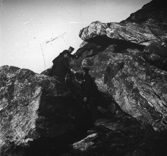 plaque de verre photographique ; Escalade d’un important éboulis rocheux par trois hommes en uniforme de marine