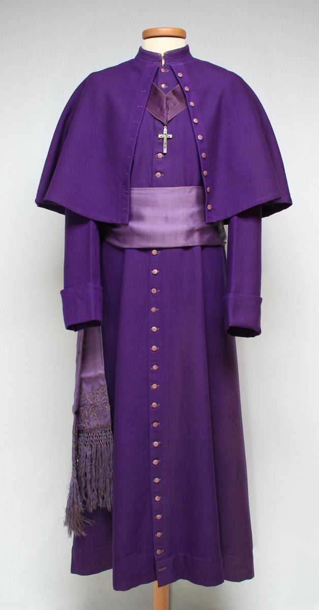costume ecclésiastique (ensemble) ; soutane (1) ; ceinture (1) ; calotte (1) ; croix pectorale (1) ; paire de gants (1)