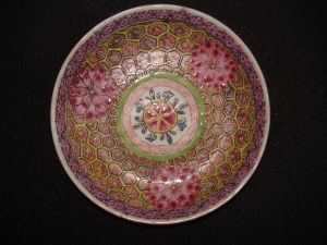 soucoupe figurant 3 fleurs séparées par des motifs décoratifs héxagonaux