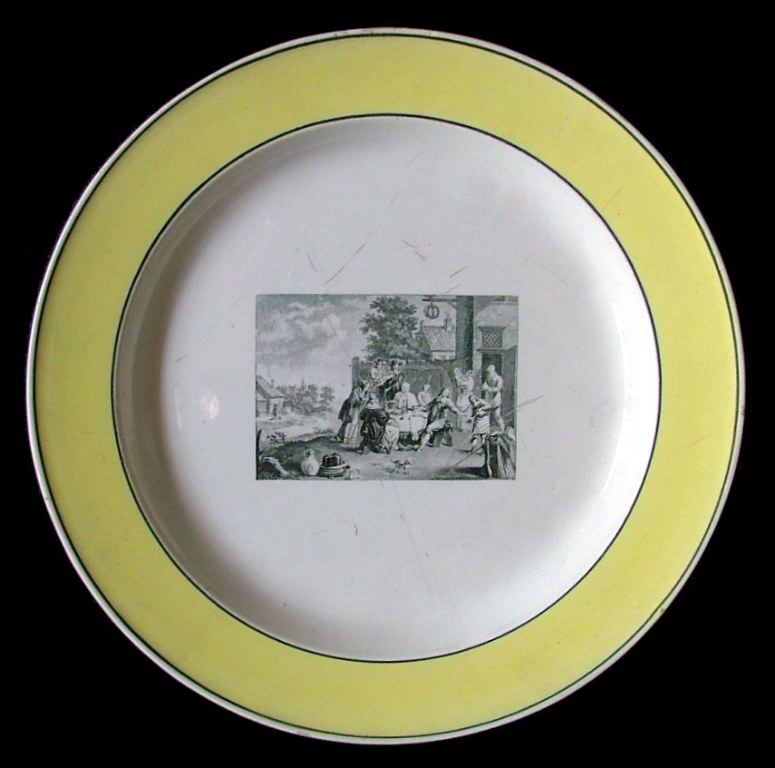 assiette historiée (ronde) ; Personnes prenant un repas dans un village (titre factice)