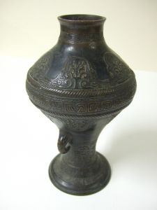 Vase asiatique avec deux petites anses à têtes d'animaux tirant la langue et nombreuses frises. (titre factice)