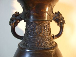 Vase asiatique avec décor de vagues sur le pied et le col, anses en têtes de dragons. (titre factice)
