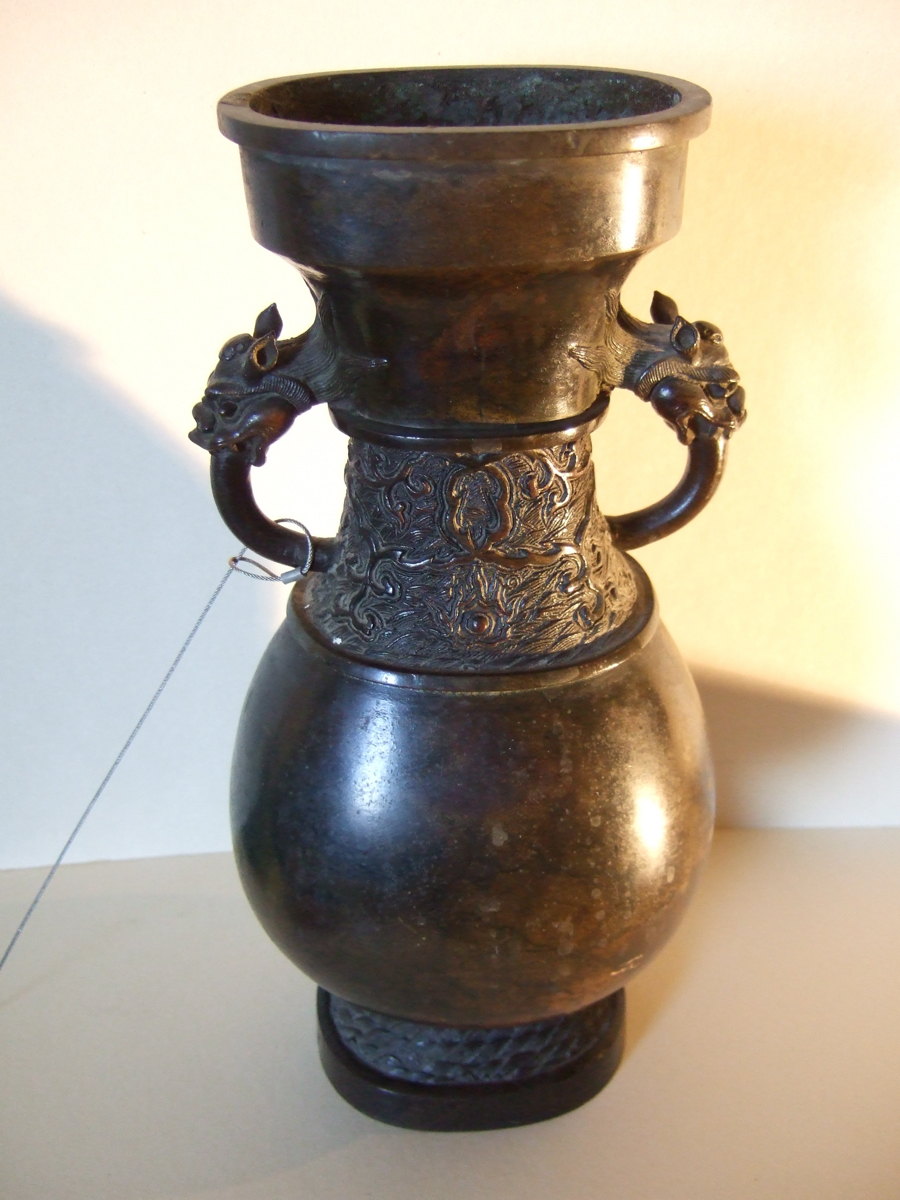 Vase asiatique avec décor de vagues sur le pied et le col, anses en têtes de dragons. (titre factice)