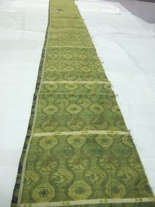 Très long morceau de tissu asiatique, motifs de médaillons alternés vert doré sur fond bleu. (1/2) (titre factice)