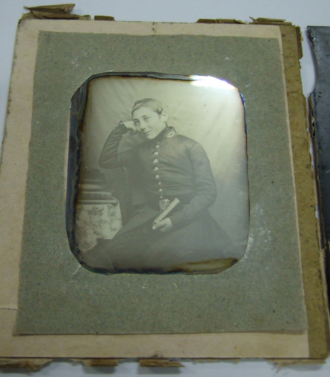Photo sur verre d'un jeune homme (Lansyer?) assis en costume, tenant un livre. (titre factice)
