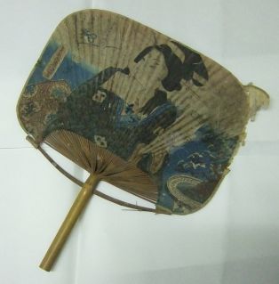 Eventail japonais avec femme tenant un livre entre ses dents en décor. (titre factice)